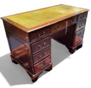 A reproduction mahogany twin pedestal desk, with green tooled leather inset writing surface, 122cm