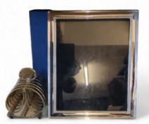 A Carrs silver plated easel photograph frame, boxed;   a seven bar toast rack (2)