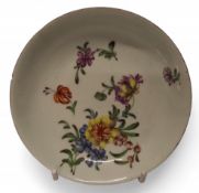 A Longton Hall saucer dish, painted in polychrome with floral spray and scattered flowers, brown
