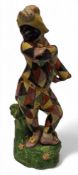 A Staffordshire figure, of a harlequin, wearing a typical chequered suit and a black mask, yellow