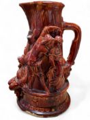 A Minton majolica ewer, moulded in relief with debaucherously figures carousing and drinking, in