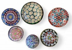 A later 20th century glass paperweight, of domed form, internally decorated with scattered complex