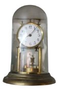 A 20th century brass Anniversary clock, with torsion pendulum, on stepped circular base, under glass