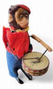 A post-war Schuco clockwork Solisto drumming monkey, brown cotton plush head, painted tinplate face,