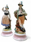 A pair of German figures, of a huntsman  and companion, in colours, 29cm high, c.1900