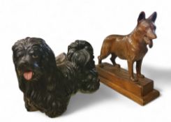 An early 20th century carved German Shepherd, rectangular plinth, 31.5cm high;   a pottery Shih