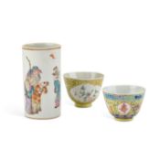 A CHINESE FAMILLE ROSE CYLINDRICAL VASE AND TWO YELLOW-GROUND BOWLS