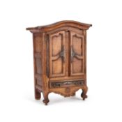 AN ANTIQUE CARVED MINIATURE ARMOIRE