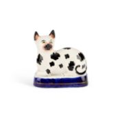A VICTORIAN STAFFORDSHIRE POTTERY MODEL OF A RECUMBENT CAT, CIRCA 1850
