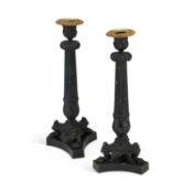 A PAIR OF REGENCY STYLE PATINATED METAL CANDLESTICKS