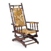 A LATE 19TH CENTURY BEECH AND UPHOLSTERED AMERICAN STYLE ROCKING CHAIR