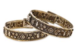 A PAIR OF REPOUSSE SILVER BANGLES