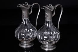 A PAIR OF FRENCH PEWTER MOUNTED GLASS CLARET JUGS