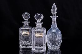 A GROUP OF THREE CRYSTAL DECANTERS AND TWO SILVER TAGS