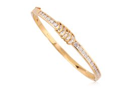 A HIGH KARAT GOLD DIAMOND HINGED BANGLE