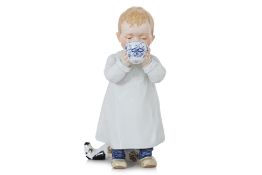A MEISSEN FIGURE OF A BOY DRINKING FROM A 'BLUE ONION' BOWL