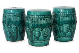 A SET OF THREE GREEN GLAZED BARREL FORM CERAMIC STOOLS