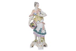 A KPM PORCELAIN FIGURE OF A SHEPHERDESS WITH FRUIT