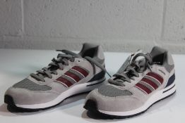 A pair of Adidas Run 80s in Grey Shadow/Red Shadow