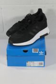 An as new pair of Adidas Retropy F2 Trainers in Black/White, Size UK 11.5 (Box Damaged).