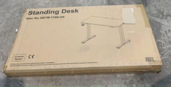 A Sanodesk Standing Adjustable Desk Boxed, New.