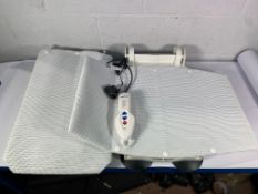 An Aquatec Orca reclining bath lift with control panel and charger. Pre-owned.