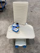 An Aquatec Orca reclining bath lift with two control units and a charger. Pre-owned.