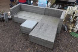 A rattan style L shaped garden settee lacking cush