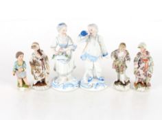 A Meissen style porcelain figure of a young boy; three German porcelain figures of two maids and a