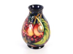 A Moorcroft fruit decorated baluster vase, with original box, 20cm high