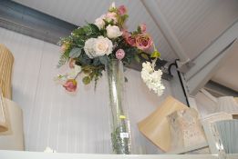 A collection of artificial flowers in a glass vase