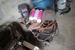 Oil filled arc welder on trolley with 3x masks, 3x gas argon canisters & a quantity of welding rods.