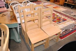 A set of four pine ladder back kitchen chairs