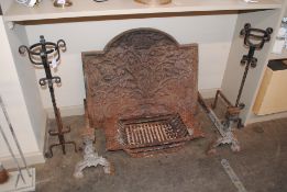 A cast iron ornate fire back, with grate and andir