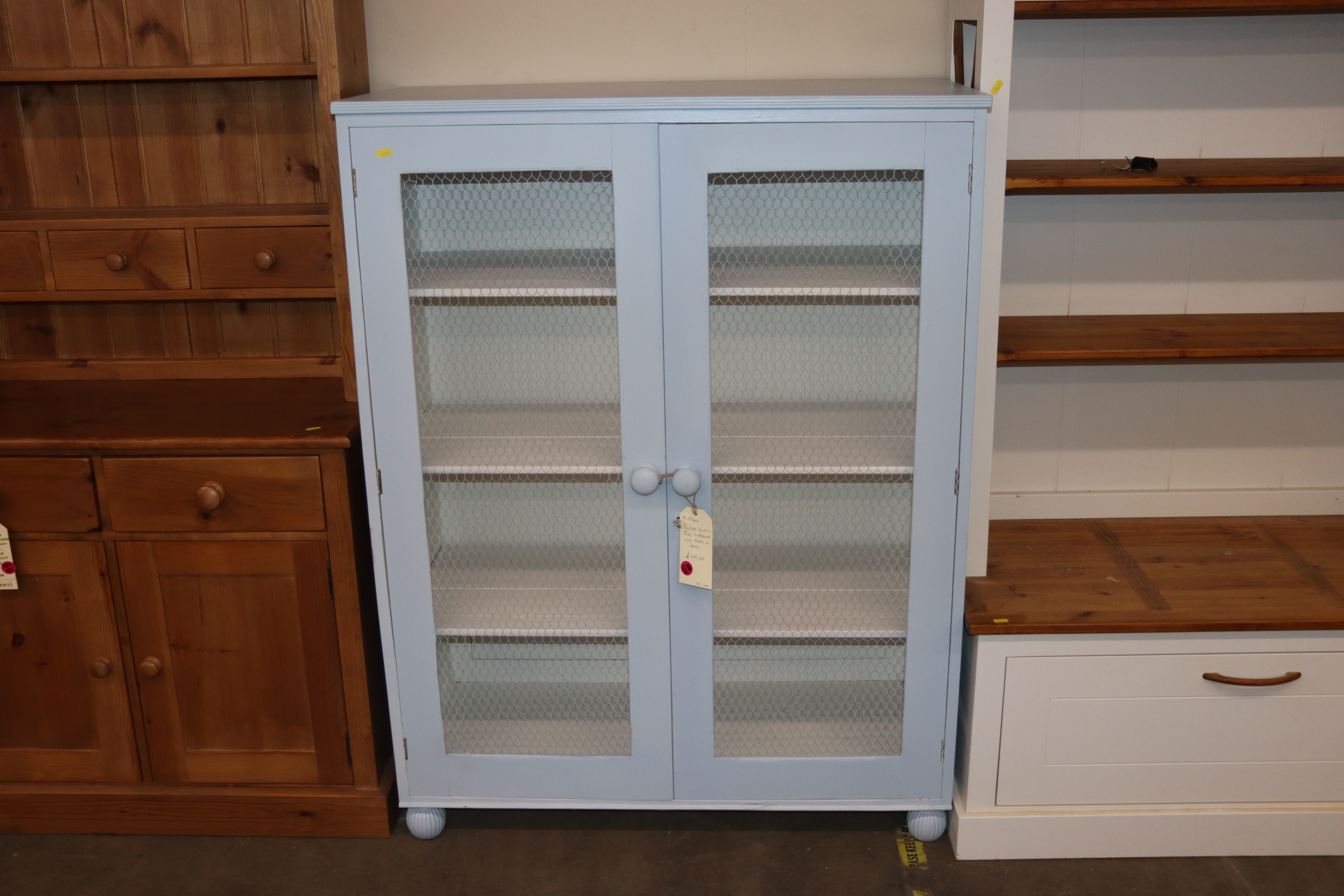 A blue painted country pine cupboard with wire mesh doors, 102cm wide