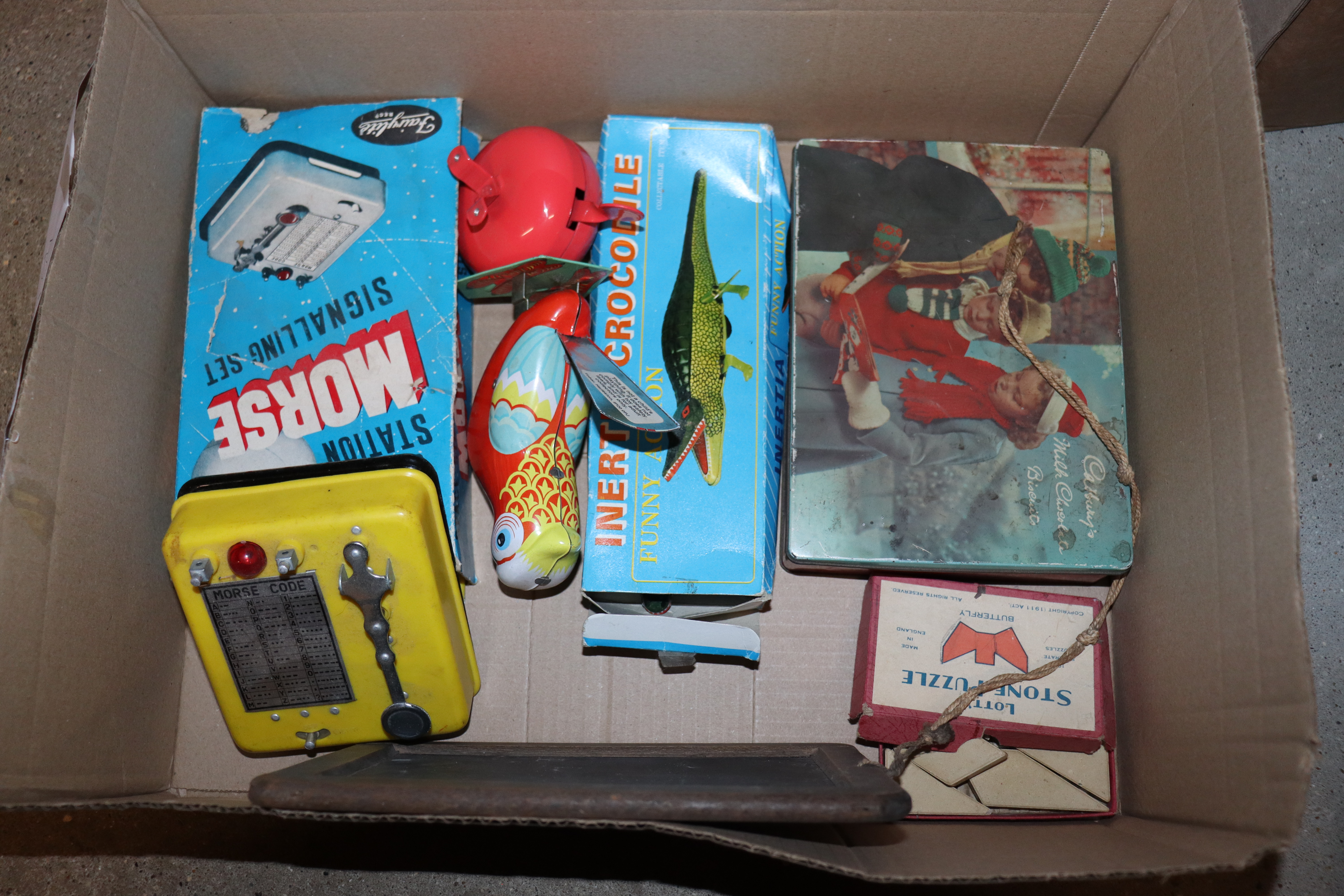 A box of various vintage tin and other toys