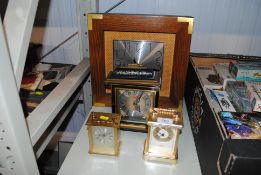 A wall clock and three other clocks