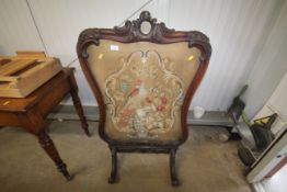 A Victorian carved mahogany wool work firescreen