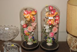 A pair of French glass domes and contents of artif