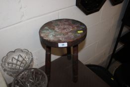 A floral painted elm seated three legged stool