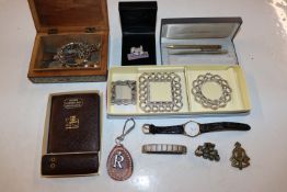 A box containing various coinage, bracelets, wrist