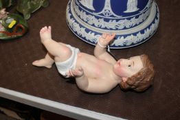 A painted and decorated cherub figure, 28cm