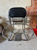 A scooter backrest, spare wheel holder and luggage rack, combined.