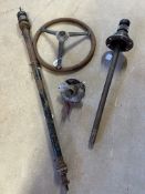 A steering column (broken at base), a steering wheel and a halfshaft and hub from a 12/4 Riley, near