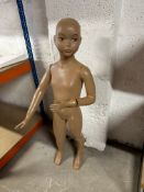An early and self-standing shop mannequin of a young girl, complete with a set of clothes.