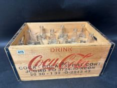 A reproduction 24-division Coca-Cola wooden drinks bottle crate with 13 contemporary Coca-Cola