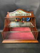 A Fry's Chocolate & Cocoa glass pediment open cabinet with lift-out front panel, mirrored back and