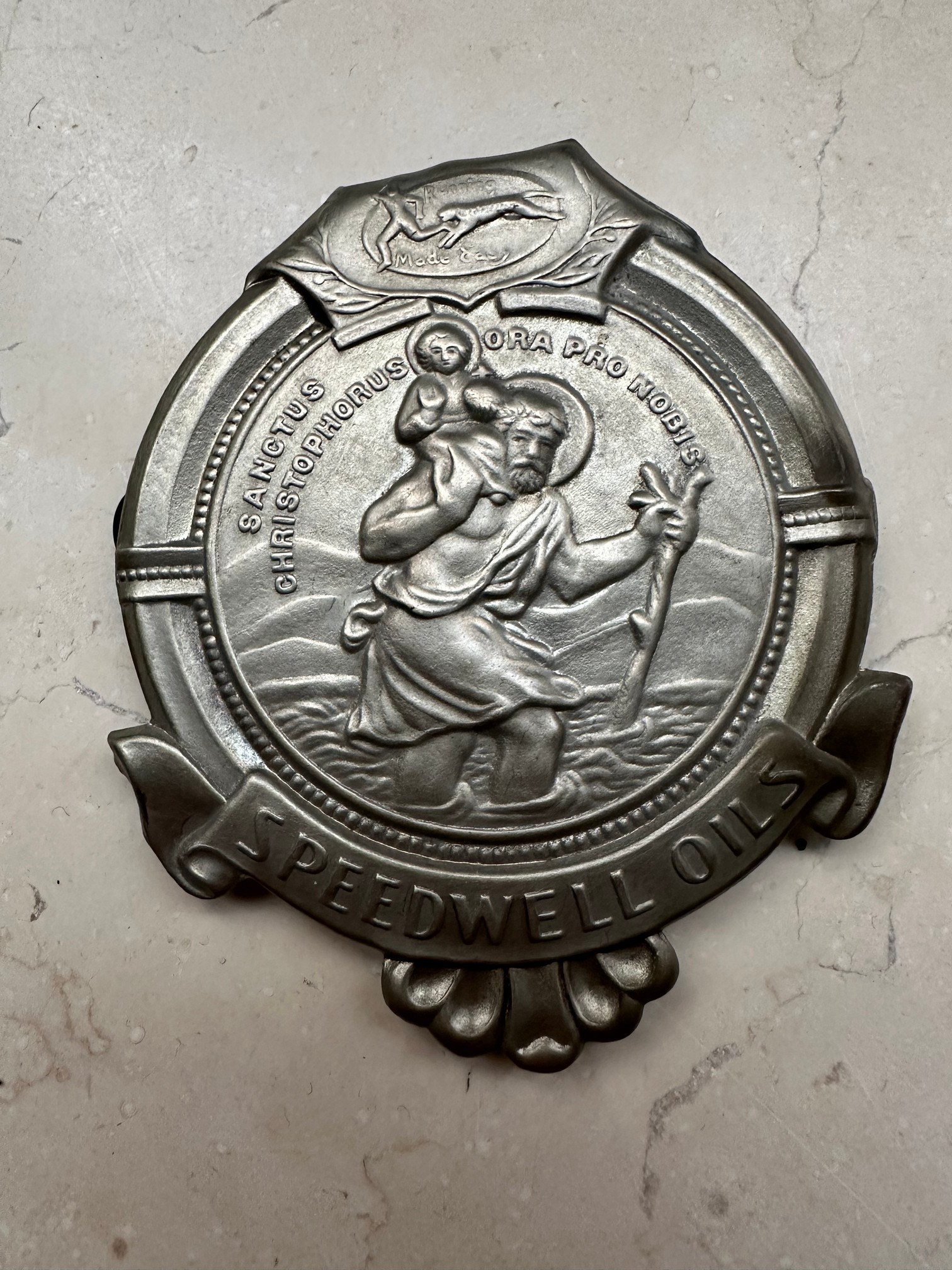 A Speedwell Oils St. Christopher (patron saint of travellers) grille badge, 3 1/2 x 3".