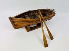 A well detailed scratch built wooden model of a rowing boat with oars