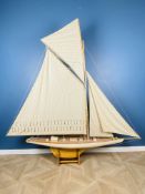 Large, single mast wooden pond yacht in full sail